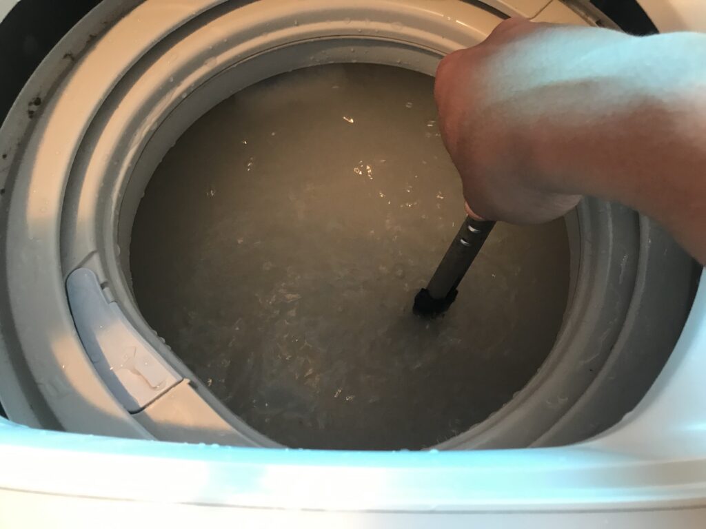 洗濯機にお湯とオキシクリーンを入れて混ぜる